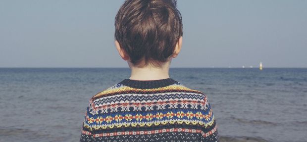 Ung gutt som ser utover havet